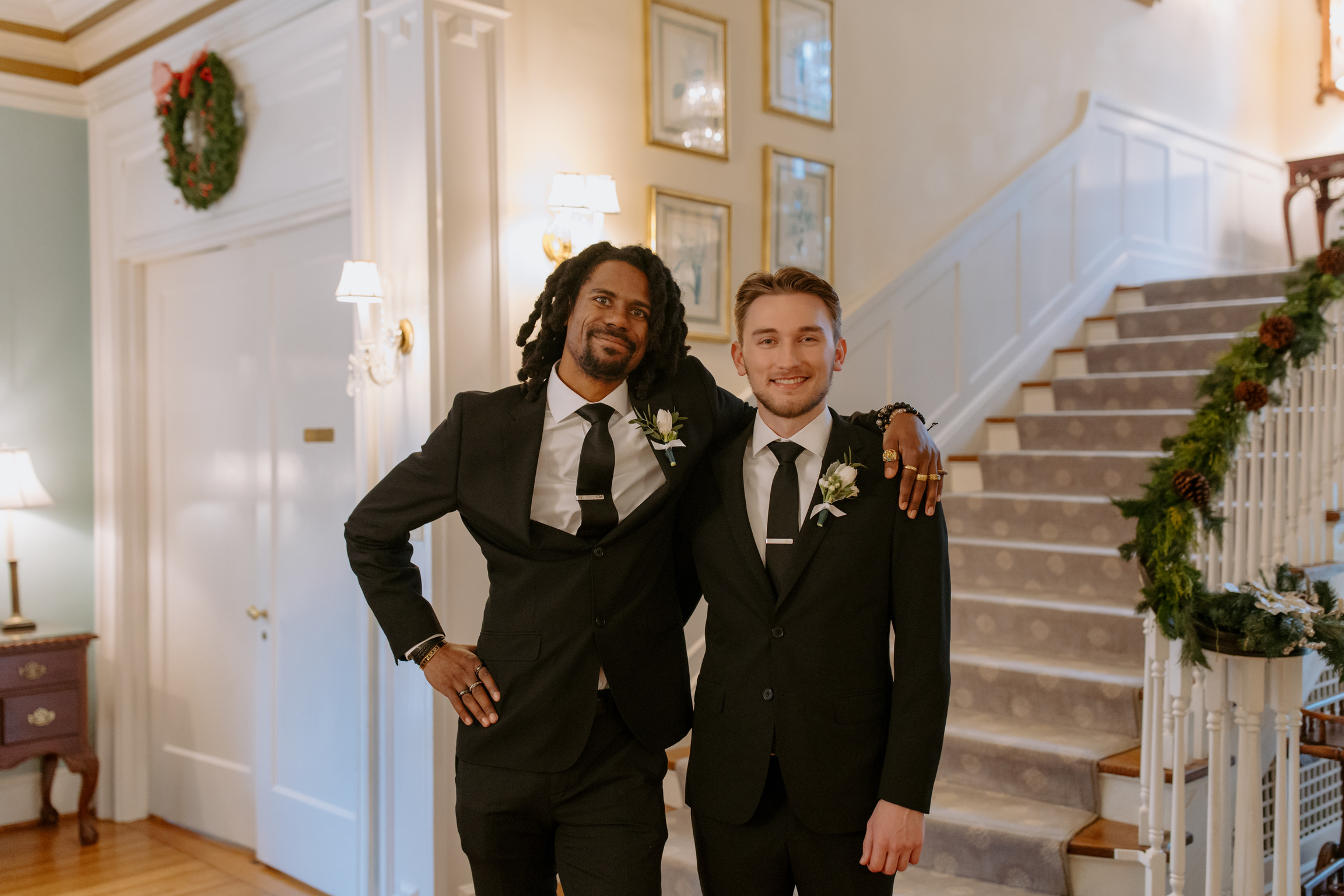 two men posing in front of stairs.